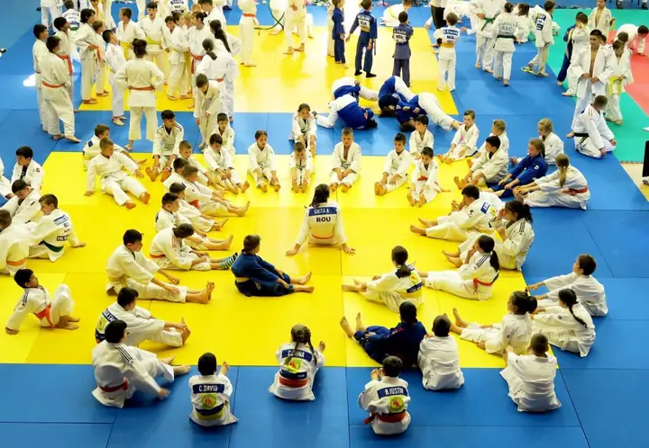 Copiii ascultă explicațiile, pe tatami